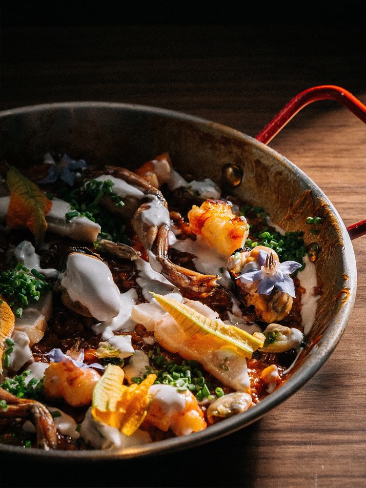 Una padella con frutti di mare ed erbe, appena uscita dalla cucina