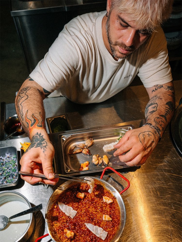 Lo chef impiatta accanto a una padella in cucina
